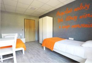 Un dormitorio con una cama y una pared con escritura. en Dom Sportowca, en Racibórz