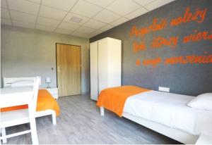 een slaapkamer met een bed en een muur met een opschrift erop bij Dom Sportowca in Racibórz