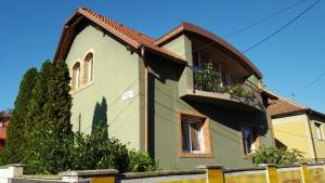 a small house with a balcony on the side of it at Szigeti Apartmanház in Pécs
