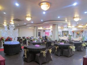 a banquet hall with tables and chairs and flowers at Merpati Hotel in Pontianak