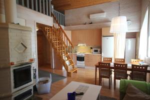 a kitchen and dining room with a spiral staircase at Villa Lotta in Virttaa