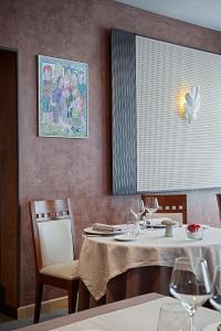 - une salle à manger avec une table, des chaises et des verres à vin dans l'établissement Logis Hôtel de france, à La Côte-Saint-André