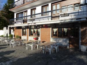 a group of tables and chairs in front of a building at Letea in Régil