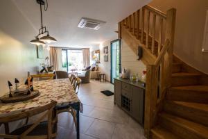 a kitchen and living room with a table and a staircase at L'ancien poulailler- The Old Hen House in Saint-Saturnin-lès-Apt