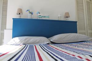 パレルモにあるCasa Ammare Circeのベッド1台(ブルーヘッドボード、枕2つ付)