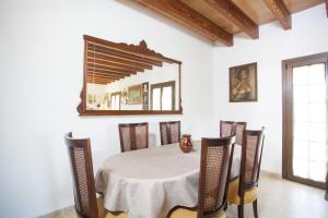 comedor con mesa, sillas y espejo en Finca Ca Nantonia, en Sa Coma