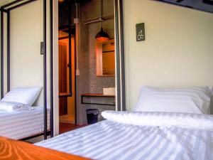 a room with two beds and a mirror at Bedgasm Hostel Chanthaburi in Chanthaburi