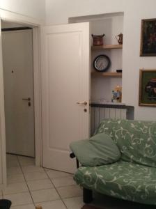 a living room with a green couch and a clock at La Casa di Rosa by PortofinoVacanze in Santa Margherita Ligure