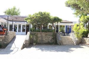 a building with a stone wall next to a street at Mobile homes Dole in Živogošće