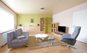 a living room with a couch and a chair and a table at Ferienwohnungen Anneliese in Neustadt an der Weinstraße