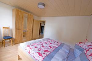 a bedroom with a bed and a chair at Ferienwohnungen Anneliese in Neustadt an der Weinstraße