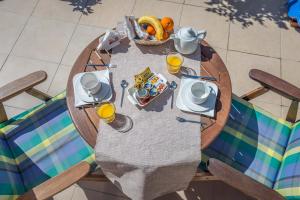 een tafel met een fruitschaal en een glas sinaasappelsap bij Hotel Delfini in Adamas