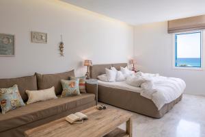 a living room with a bed and a couch at Poseidon of Paros Hotel & Spa in Chrissi Akti