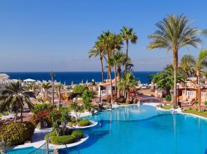 a resort with a large swimming pool with palm trees at Sol Sun Beach Apartamentos in Adeje +21 photos