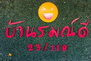 a sign with a smiley face on the grass at Baan Romdee in Nonthaburi