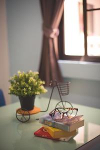 un par de gafas sentadas encima de los libros en una mesa en Baan Romdee, en Nonthaburi
