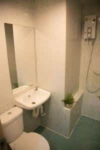 a bathroom with a toilet and a sink and a shower at Baan Romdee in Nonthaburi