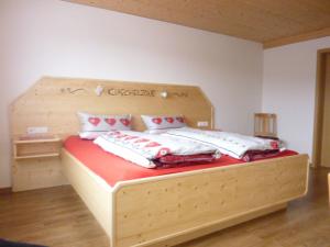 1 dormitorio con cama de madera y almohadas en Hochtalblick, en Bernau im Schwarzwald