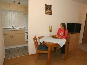 Eine Frau, die an einem Tisch mit einem Teller Essen sitzt. in der Unterkunft Hochtalblick in Bernau im Schwarzwald