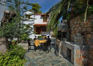 a patio with a table and chairs and a building at Kamelia Villas in Votsi