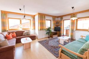salon z kanapą i telewizorem w obiekcie Appartement Alpina w Alpbach