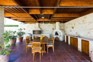 an outdoor patio with a table and chairs and an oven at Winehill Villa in Platanias