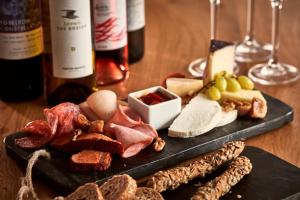 a plate of meats and cheese and wine bottles at Poseidon of Paros Hotel & Spa in Chrissi Akti