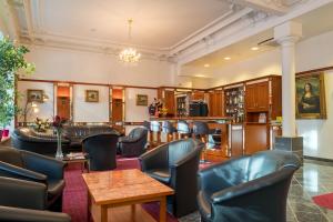 a waiting room with leather chairs and tables at Hotel Bayernland in Munich