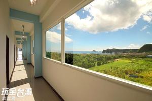 a room with a large window with a view of the ocean at Jing Long Homestay in Green Island