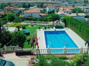 un hombre está saltando a una piscina en Villa Nazari, en Otura