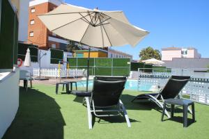 a table and chairs with an umbrella next to a pool at Deluxe Hostels & Suites Merida in Merida