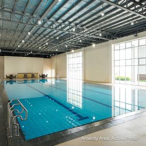 a large swimming pool with blue water in a building at Wind Residences by Bea and RM in Tagaytay