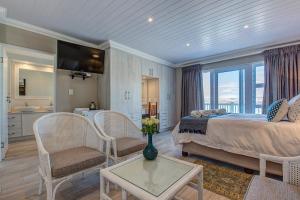 a bedroom with a bed and a living room at Marine Manor in Mossel Bay
