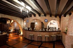 a bar with stools in a room with brick walls at Hotel Doña Teresa in La Alberca