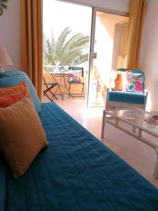 a bedroom with a bed and a table and a patio at Venturamar in Gran Tarajal