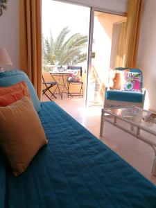 a bedroom with a bed and a table and a patio at Venturamar in Gran Tarajal
