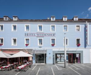 
a large building with several tables and chairs in front of it at Hotel Weidenhof in Regensburg
