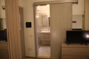 a bathroom with a mirror and a sink and a television at B&B Castello Salvaterra in Iglesias