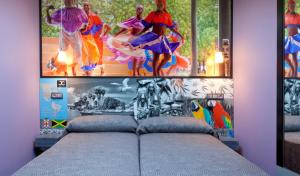 um quarto com uma cama com pinturas na parede em JC Rooms Chueca em Madrid