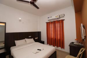 ein Schlafzimmer mit einem Bett und einem roten Vorhang in der Unterkunft KV Residency in Coimbatore