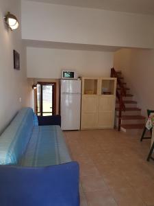 ein Wohnzimmer mit einem Kühlschrank und einer Küche in der Unterkunft Domus Budoni 1 in Budoni
