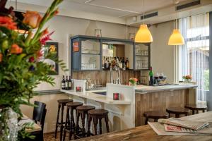 eine Bar in einem Restaurant mit Hockern in der Unterkunft Campanile Hotel & Restaurant 's Hertogenbosch in ’s-Hertogenbosch