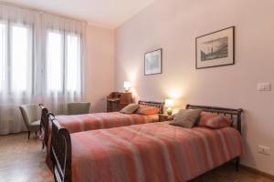 a bedroom with two beds and a desk and windows at Rialto Bridge Big apt with Lift by LionHost in Venice