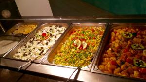 a buffet with four trays of different types of food at Arena Mar Hotel and SPA in Golden Sands