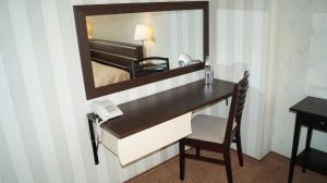 a desk in a hotel room with a mirror at Podkova Omsk na Prospekte Gubkina in Omsk