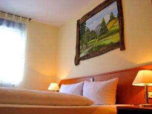 a hotel room with a bed and a painting on the wall at Hotel Harzlodge in Goslar
