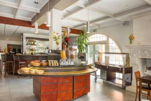 ein Restaurant mit einer Theke, auf der Essen angeboten wird in der Unterkunft Cévenol Hôtel in Millau
