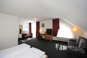 a hotel room with a bed and a living room at Christkönigshaus in Stuttgart