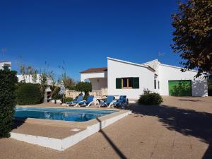 a villa with a swimming pool in front of a house at Villa Luz in Cala en Blanes