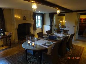 a dining room with a table and a fireplace at Moulin de Sévoux in Malétable